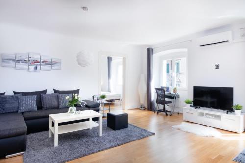 uma sala de estar com um sofá e uma televisão em Apartment Santa Barbara em Rijeka