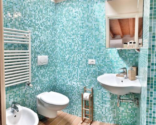 uma casa de banho em azulejos azuis com um WC e um lavatório em Casa Danema em Sirmione