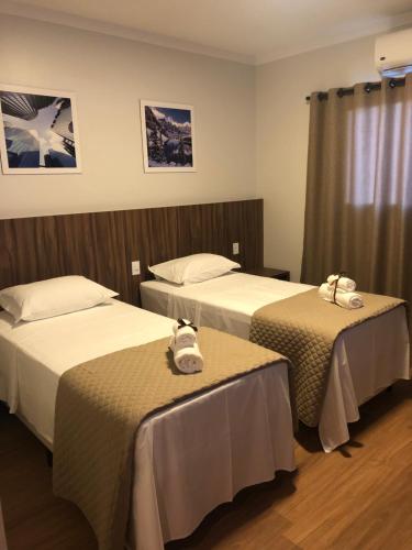 HOTEL ROYAL AMAMBAI في Amambaí: غرفه فندقيه سريرين عليها مناشف