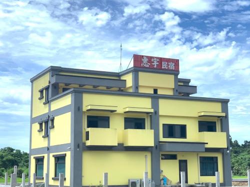 a yellow building with a sign on top of it at 太魯閣惠宇民宿 in Xincheng