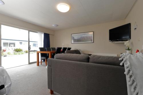 a living room with a couch and a television at Aden Motel in Te Anau