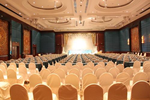 an empty auditorium with white chairs and a stage at Golden Tulip Sovereign Hotel Bangkok in Bangkok
