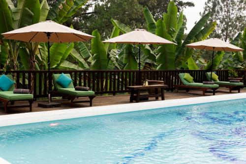 a swimming pool with chairs and tables and umbrellas at Hotel Boutique y Restaurante Panisté in Santa Cruz Verapaz