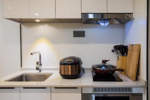 a kitchen with a sink and a pot on a stove at Shenzhen Fashion LOFT Apartment in Shenzhen