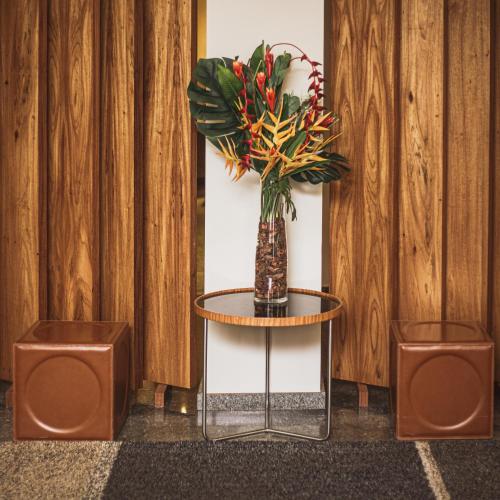a vase of flowers on a table with two speakers at Mara Turismo Hotel in Catalão