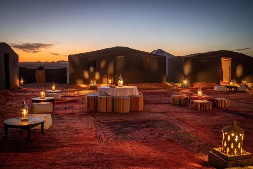 Camp Sahara Holidays في امحاميد: مجموعة من الخيام مع الشموع في الصحراء