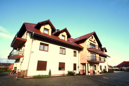 a large white building with a red roof at Pensjonat Korona in Modrzyca