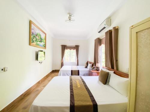 1 Schlafzimmer mit 2 Betten und einem Fenster in der Unterkunft Gold Plus Hotel in Phong Nha
