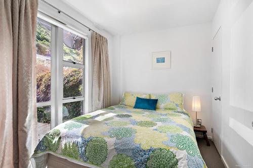 Schlafzimmer mit einem Bett vor einem Fenster in der Unterkunft TrinketBox in Wellington