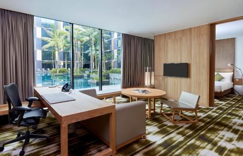 a hotel room with a desk and a table and chairs at Crowne Plaza Changi Airport by IHG in Singapore