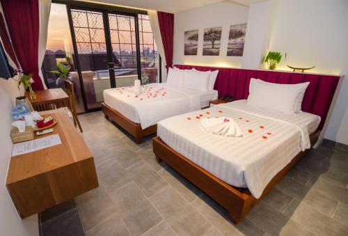 une chambre d'hôtel avec deux lits et un balcon dans l'établissement Neth Socheata Hotel, à Siem Reap