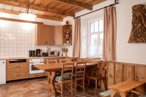a kitchen with a wooden table and wooden chairs at Penzion Medvídek Tanvald in Tanvald