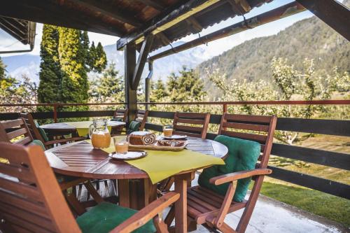 a wooden table and chairs on a patio with a view at Turistična Kmetija Zgornji Zavratnik in Luče