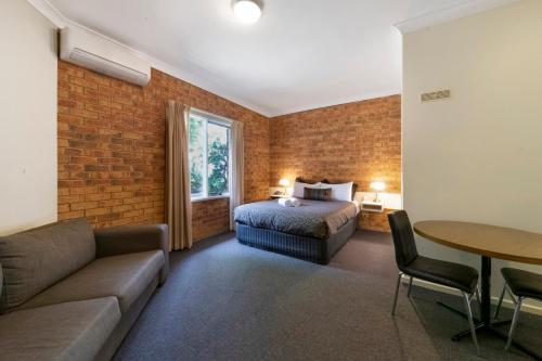 a hotel room with a bed and a couch at Broadford Sugarloaf Motel in Broadford