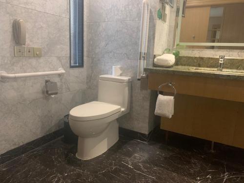 a bathroom with a white toilet and a sink at Wyndham HangZhou East in Hangzhou