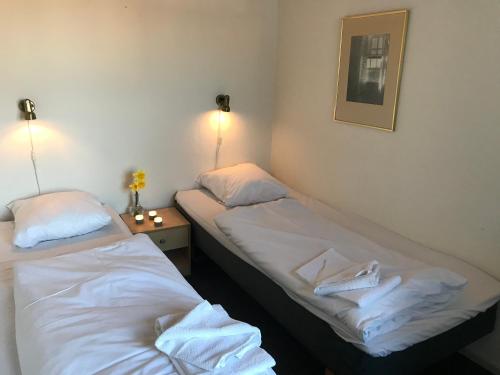 2 łóżka pojedyncze w pokoju ze zdjęciem na ścianie w obiekcie Medio Apartments w mieście Fredericia