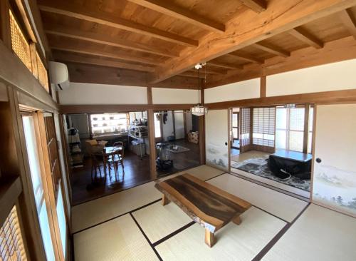 uma sala de estar em plano aberto com um tecto de madeira em KOME HOME em Tokamachi
