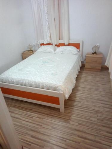 a bed in a bedroom with a wooden floor at Villa Angela, Traditional house in the village in Agios Ioannis Peristerion