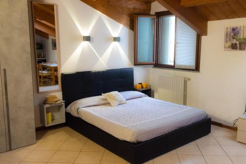 a bedroom with a large bed with lights on the wall at Monolocale vicino Milano CIR 00014 in Lodi