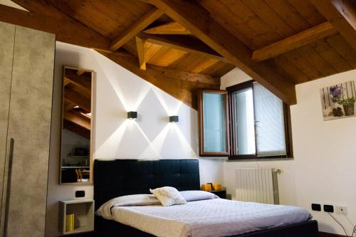 a bedroom with a large bed with wooden ceilings at Monolocale vicino Milano CIR 00014 in Lodi
