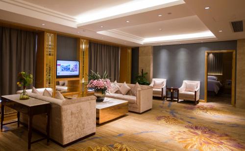 a living room with couches and a television at Wyndham HangZhou East in Hangzhou