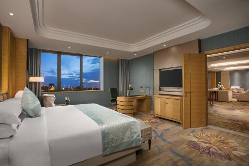 a hotel room with a bed and a television at Wyndham HangZhou East in Hangzhou