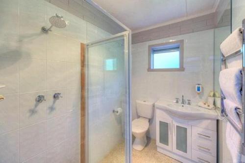 a bathroom with a shower and a toilet and a sink at Best Western Burnie - Murchison Lodge in Somerset