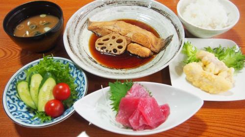 a table with plates of food and bowls of food at 旅館いしのまき in Ishinomaki