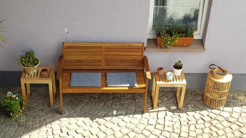 a wooden bench and two tables and a window at Die kleine Karthause in Konz