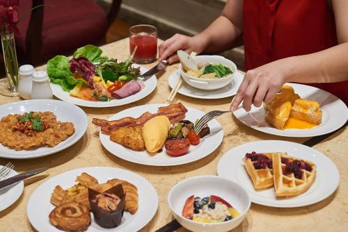 a table with plates of food on it at Grand Hyatt Erawan Bangkok in Bangkok