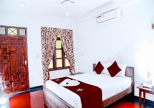 a bedroom with a bed and a window at Crescent Sea Resort in Nilaveli