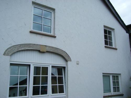 a white house with an arch over a window at Die kleine Karthause in Konz