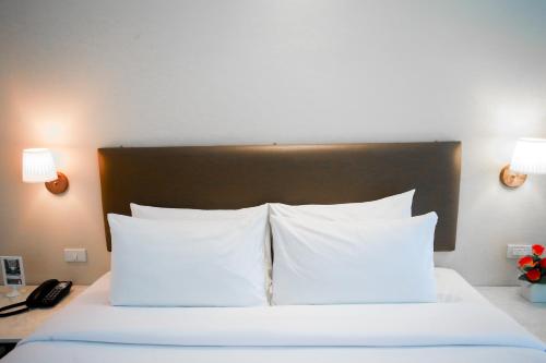 a bedroom with a bed with white pillows at Summer Tree Hotel in Bangna