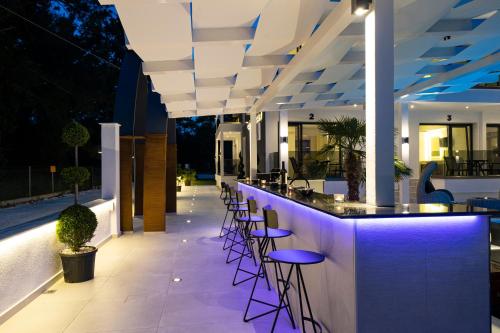 an outdoor bar with purple stools on a building at Avaton Luxury Resort and Spa Access the Enigma - Adults Only & Kids 14 Plus- in Asprovalta