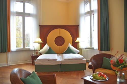 a bedroom with a bed in a room with windows at Hotel Villa Ponte Wisera in Eschwege