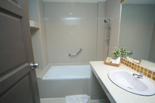 a bathroom with a sink and a bath tub at Summer Tree Hotel in Bangna
