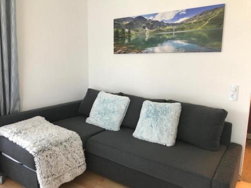 a living room with a gray couch with pillows at BohnApart52 in Zwiesel