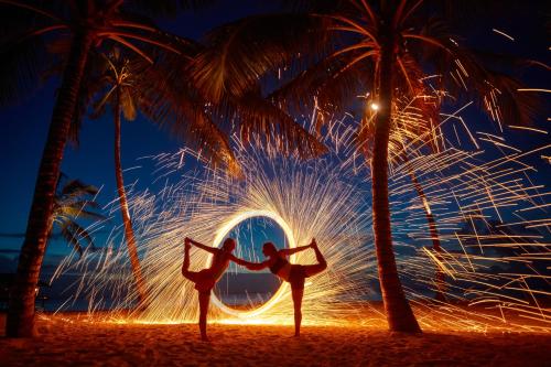 a couple of people dancing on a beach with palm trees at Pullman Maldives Maamutaa - All-Inclusive Resort - 50 percent off Transfers in Maamutaa