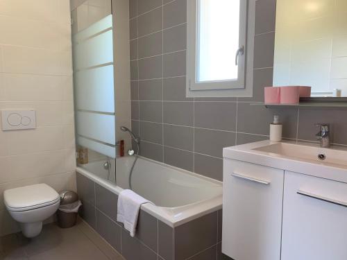 a bathroom with a tub and a toilet and a sink at Villa Catalina in Annecy
