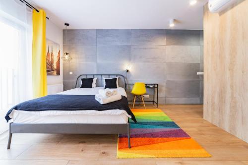 una camera da letto con un letto e un tappeto arcobaleno di Odra View Apartments a Breslavia