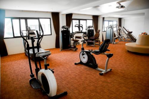 a gym with several exercise bikes and treadmills at Summer Tree Hotel in Bangna