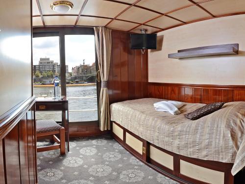 ein Schlafzimmer auf einem Boot mit einem Bett und einem Schreibtisch in der Unterkunft Florentina boat in Leitmeritz