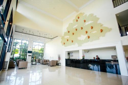 a lobby with a large tree hanging from the wall at Summer Tree Hotel in Bangna