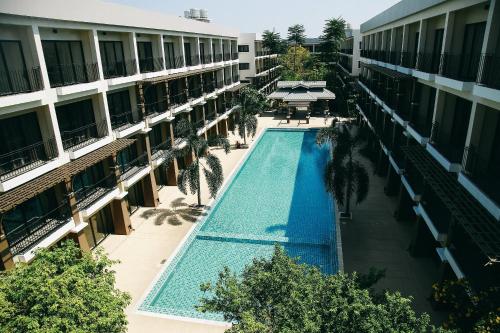 einen Blick über den Innenhof eines Apartmentgebäudes mit Pool in der Unterkunft Summer Tree Hotel in Bangna
