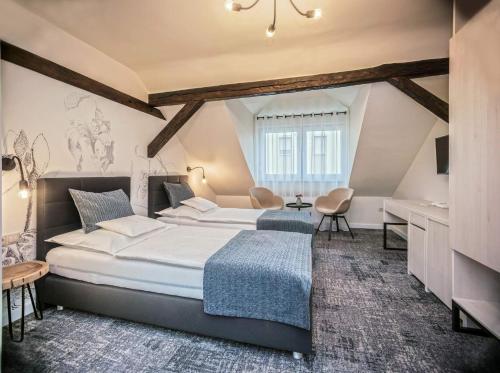 a bedroom with a large bed and a desk at Piccolo Panzió Vendéglő Vinoteca in Zalaegerszeg