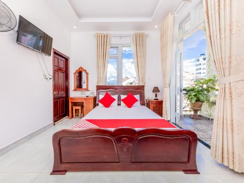 een slaapkamer met een groot bed met rode kussens bij OYO 446 The Bao Hotel in Da Lat