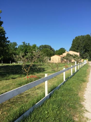a white fence along a road at B&B et Gite d'ayran in Saint-Quentin-la-Poterie