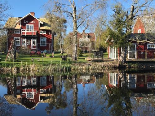 a group of houses sitting next to a body of water at Lottas stuga in Smedjebacken