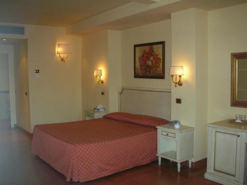 a bedroom with a bed with a red bedspread at Hotel Quadrifoglio Roma Eur in Mostacciano 