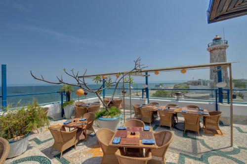 a restaurant with tables and chairs and a lighthouse at The Promenade in Puducherry